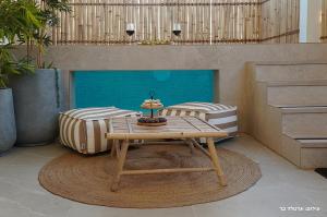 a room with a table and two beds at Shilo Boutiqe Suites in Mishmār Hāyardin