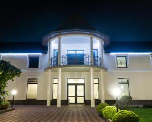 a large white building with a balcony on top at Galaktyka Hotel in Stantsiya Biskovitse