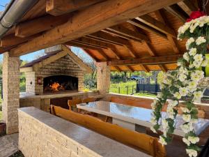an outdoor patio with a stone fireplace and a table at Apartman Šimić in Gračac +13 photos
