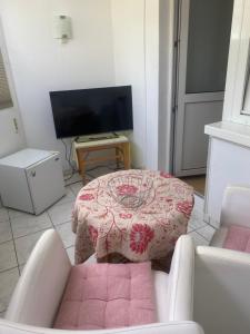 a living room with a table and a tv at Hotel Sylvia in Norderney