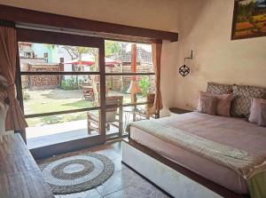 a bedroom with a bed and a view of a patio at Classico Gili Air in Gili Islands