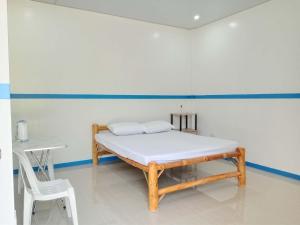 a bed in a room with a table and a chair at Juliet's Homestay in Moalboal