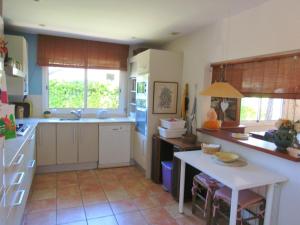 a kitchen with white cabinets and a table in it at Casa adosada en Calella de Palafrugell in Palafrugell