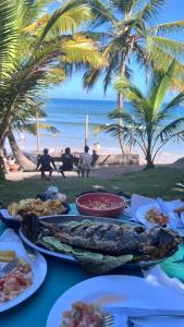a table with plates of food on the beach at CASA NANDOS Studio quintal da mata !!! in Itacaré