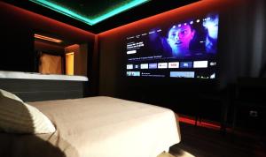a bedroom with a bed and a large television at Le secret in Nîmes
