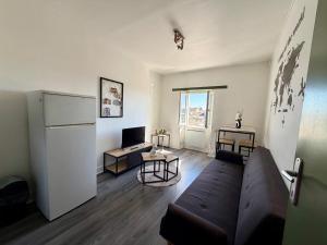 a living room with a couch and a refrigerator at Appartement VAIS in Cognac