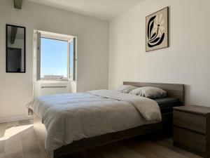 a bedroom with a large bed and a window at Appartement VAIS in Cognac