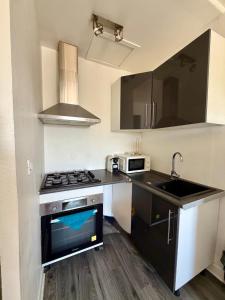 a small kitchen with a stove and a sink at Appartement VAIS in Cognac