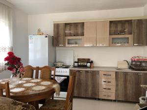 a kitchen with a table and a white refrigerator at Rugova Vila in Peje