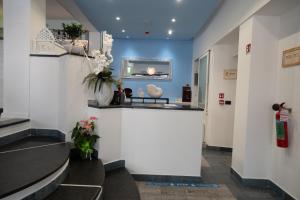 a waiting room with a counter and flowers on the wall at Hotel Estense in Bellaria-Igea Marina