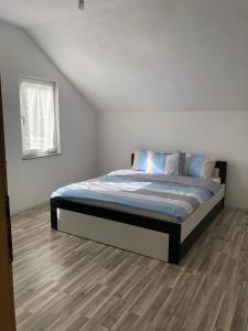 a bedroom with a bed in a white room at Rugova Vila in Peje