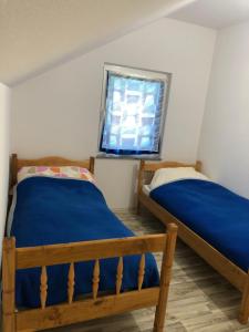 two beds in a room with a window at Rugova Vila in Peje