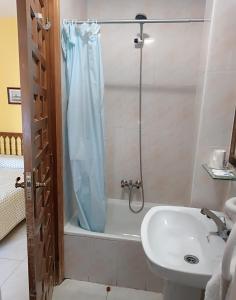a bathroom with a shower curtain and a sink at Hostal Restaurante Yagual in Sahagún +12 photos