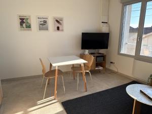 a living room with a table and chairs and a tv at La Bergerie 2 in Neufchâteau