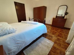 a bedroom with a bed and a dresser and a mirror at Toca da Raposa in Estremoz