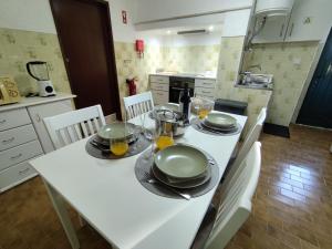 a kitchen with a white table with plates and utensils at Toca da Raposa in Estremoz