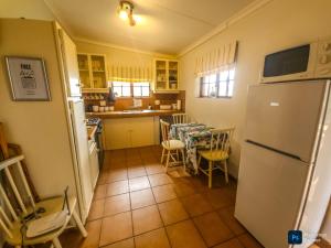 a kitchen with a refrigerator and a table with chairs at The GingerPig Inn in Die Ark