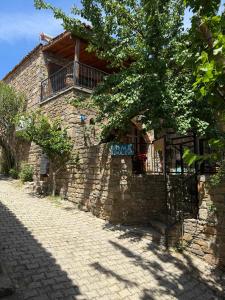 a stone building with a balcony on the side of it at Vama Konuk Evi in Gokceada Town