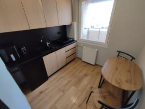 a kitchen with a table and a sink and a window at Aparto 1 in Złotów