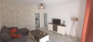 a living room with a couch and a television at Kamer Appartement in Arico in La Sabinita