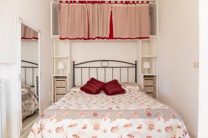 a bedroom with a bed with two red pillows at Nice villa only 100m from the beach in Fregene
