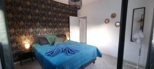 a bedroom with a bed with blue sheets and a wall at Kamer Appartement in Arico in La Sabinita +7 photos