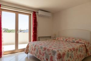 a bedroom with a bed and a large window at Nice villa only 100m from the beach in Fregene