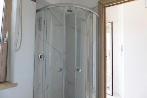 a shower with a glass door in a bathroom at Nice villa only 100m from the beach in Fregene