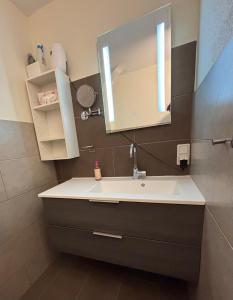a bathroom with a sink and a mirror at Haus Waldesruh, 3 Ferienwohnungen in Hemfurth-Edersee