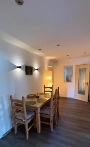 a dining room with a wooden table and chairs at Haus Waldesruh, 3 Ferienwohnungen in Hemfurth-Edersee