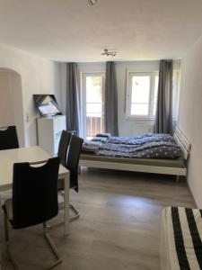 a bedroom with a bed and a desk and chairs at Am Wald, Am Berg in Unterreichenbach