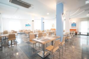 a dining room with tables and chairs at Hotel Estense in Bellaria-Igea Marina