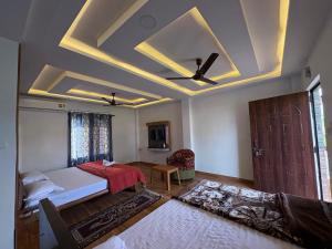 a bedroom with a bed and a ceiling fan at North Queen Resort in Mal bazar
