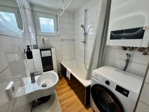 a bathroom with a sink and a washing machine at Apartment SeeZeit - Top Lage & nahe am Bodensee in Friedrichshafen +28 photos