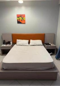a bed in a room with two night stands at Backpackersnest in Entebbe