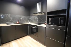 a kitchen with a microwave oven and a sink at Le secret in Nîmes