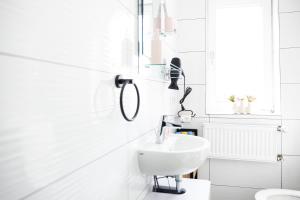a white bathroom with a sink and a toilet at Mediterran Apartments-Cabernet Sauvignon in Fulda +30 photos