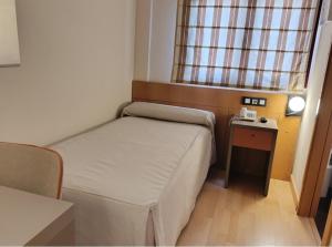 a small room with a bed and a table at Hotel Villa de Zaragoza in Casetas