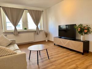 a living room with a couch and a tv at Apartment SeeZeit - Top Lage & nahe am Bodensee in Friedrichshafen