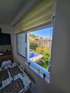 a bedroom with a window with a view of a pool at Brita Apartman in Utjeha