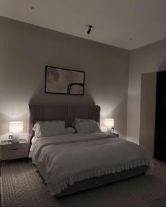 a bedroom with a large bed with two lamps at منتجع دار DAR Resort in Hail +13 photos