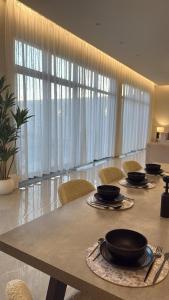 a dining room with a table and chairs and curtains at منتجع دار DAR Resort in Hail