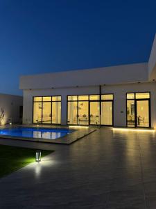 a large building with a swimming pool at night at منتجع دار DAR Resort in Hail