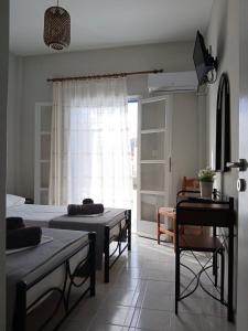 a bedroom with two beds and a window at Andromeda in Ios Chora