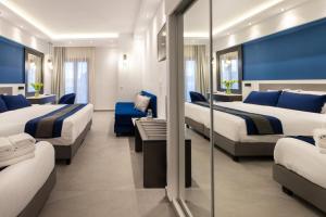 Ein Hotelzimmer mit zwei Betten und blauen Wänden in der Unterkunft Sokratis Hotel in Nea Moudania
