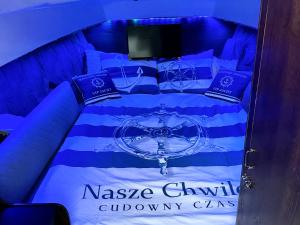 a bed with blue and white sheets and pillows at VIP JACHT in Polańczyk