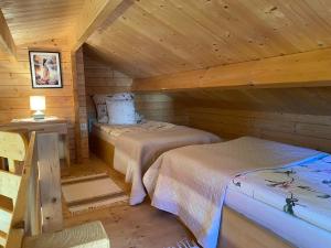 a bedroom with two beds in a log cabin at Domek pod Świerkiem in Wapnica