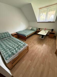 a room with two beds and a table in it at agroturystyka Pensjonat PAULA in Muszyna