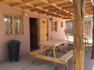 a picnic table and bench in front of a house at Refugio Don Natu in San Pedro de Atacama