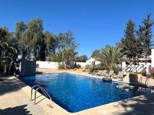 a swimming pool with blue water and palm trees at Rezen Villas in Lorca